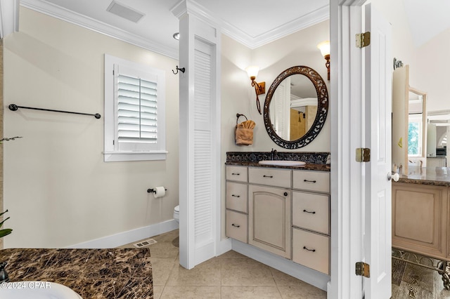 bathroom featuring toilet, vanity, tile patterned floors, and ornamental molding