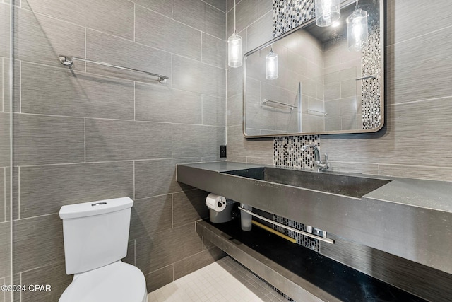 bathroom with toilet and tile walls