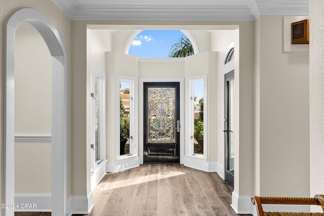 foyer entrance with ornamental molding and hardwood / wood-style floors