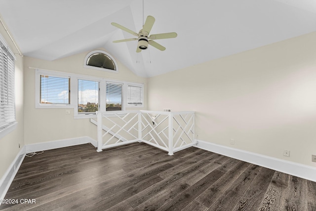 spare room featuring vaulted ceiling, ceiling fan, a healthy amount of sunlight, and dark hardwood / wood-style floors