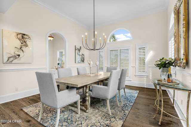 dining area featuring dark hardwood / wood-style flooring, crown molding, and a chandelier