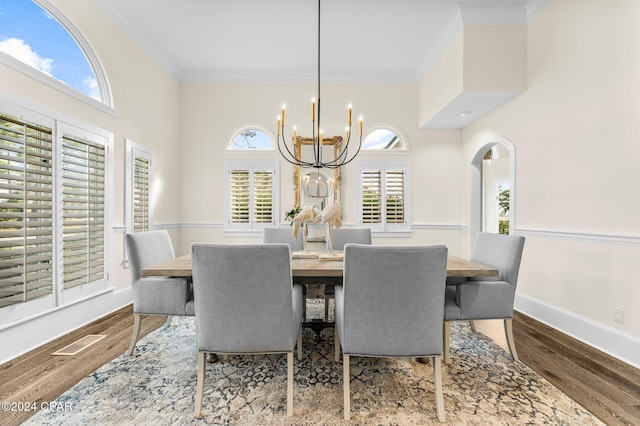 dining space with a chandelier, ornamental molding, and wood-type flooring