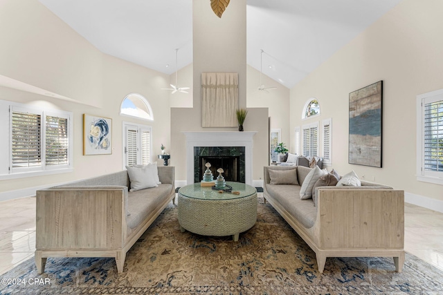 living room featuring high vaulted ceiling, a healthy amount of sunlight, and a premium fireplace