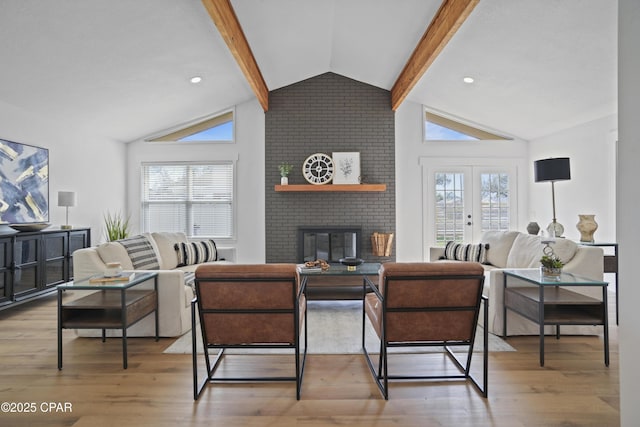 living area with lofted ceiling with beams, french doors, plenty of natural light, and wood finished floors