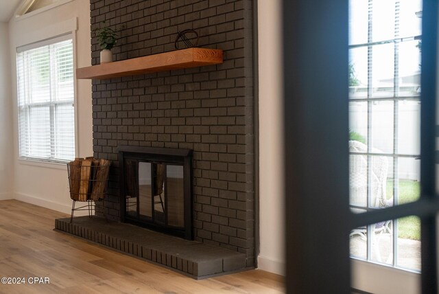 details with a fireplace, baseboards, and wood finished floors