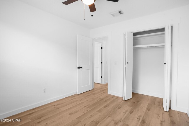 unfurnished bedroom featuring a ceiling fan, visible vents, baseboards, a closet, and light wood finished floors