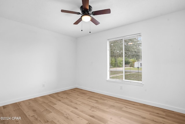 spare room featuring baseboards, ceiling fan, and light wood-style floors