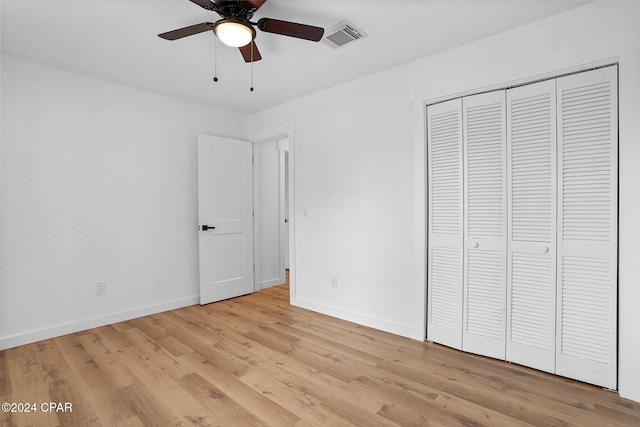 unfurnished bedroom with visible vents, baseboards, light wood-style flooring, ceiling fan, and a closet