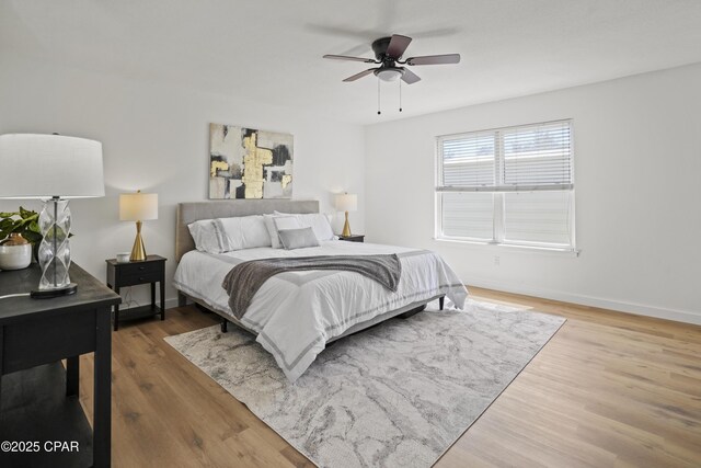 bedroom featuring ceiling fan, wood finished floors, and baseboards