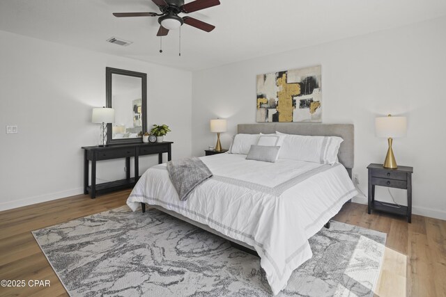 bedroom featuring visible vents, baseboards, and wood finished floors