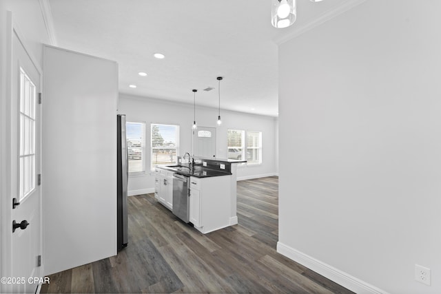 kitchen featuring sink, appliances with stainless steel finishes, pendant lighting, a kitchen island with sink, and white cabinets