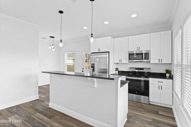 kitchen with white cabinetry, decorative light fixtures, a kitchen breakfast bar, a kitchen island, and stainless steel appliances