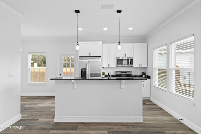 kitchen with white cabinetry, stainless steel appliances, a kitchen island with sink, and a breakfast bar area