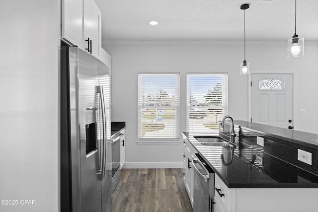 kitchen featuring decorative light fixtures, sink, white cabinets, dark stone counters, and stainless steel appliances