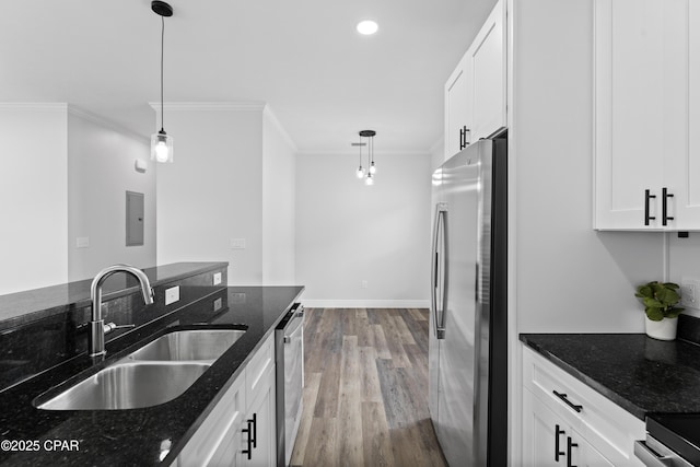 kitchen with white cabinetry, hanging light fixtures, dark stone counters, and appliances with stainless steel finishes