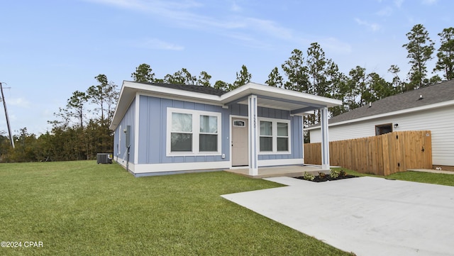 view of front of home featuring a patio, central AC, and a front lawn