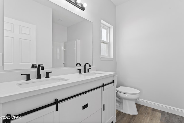 bathroom featuring vanity, toilet, wood-type flooring, and a shower