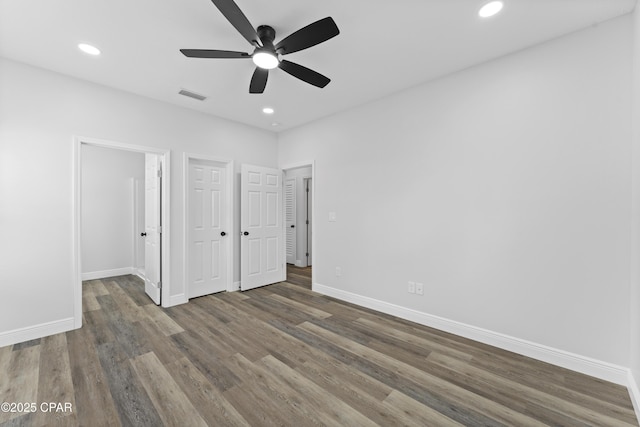 unfurnished bedroom with ceiling fan and dark hardwood / wood-style flooring