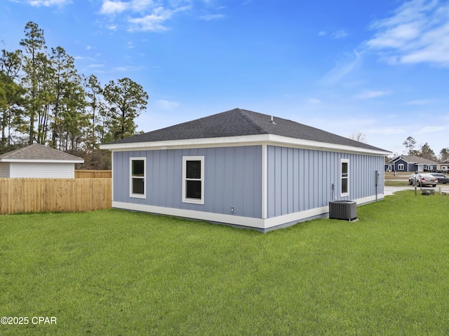 rear view of property featuring a yard and central AC unit