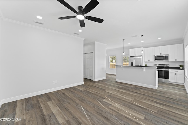 kitchen with crown molding, decorative light fixtures, a center island, stainless steel appliances, and white cabinets