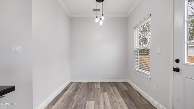 unfurnished dining area with hardwood / wood-style flooring and crown molding