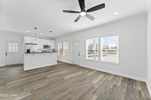 unfurnished living room featuring hardwood / wood-style floors, crown molding, and ceiling fan