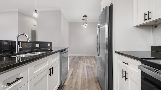 kitchen featuring white cabinets, stainless steel appliances, hanging light fixtures, and sink