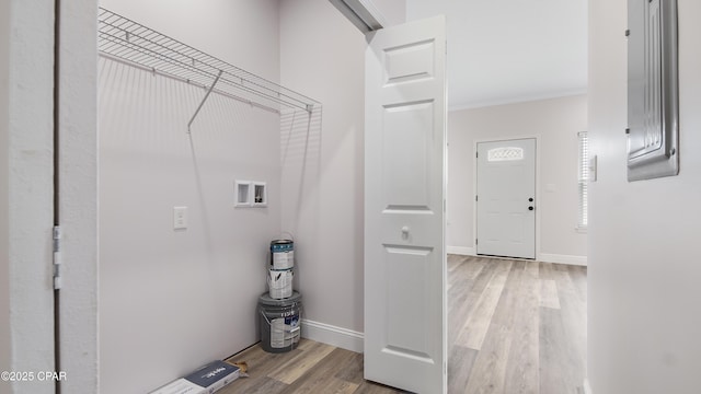 washroom featuring ornamental molding, washer hookup, and light hardwood / wood-style floors