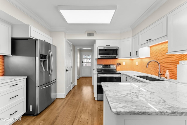 kitchen featuring stainless steel appliances, crown molding, sink, light hardwood / wood-style floors, and white cabinetry