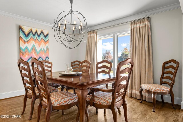 dining area with a chandelier, light wood-type flooring, and ornamental molding