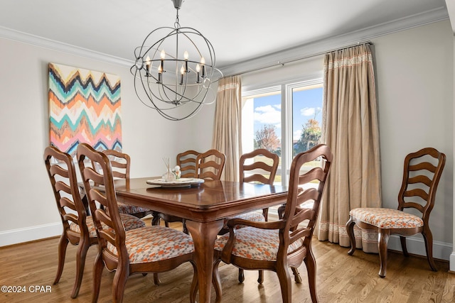 dining room with light wood-type flooring, crown molding, baseboards, and an inviting chandelier