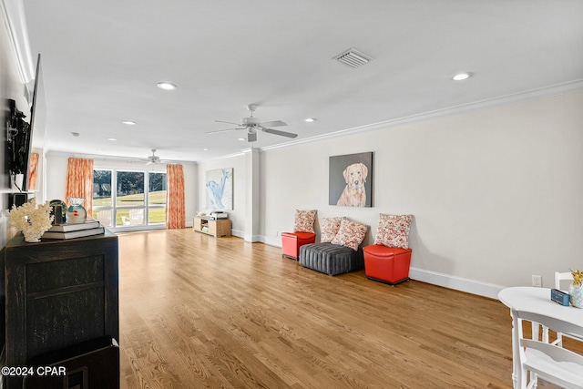 sitting room with light wood-type flooring, ceiling fan, and ornamental molding