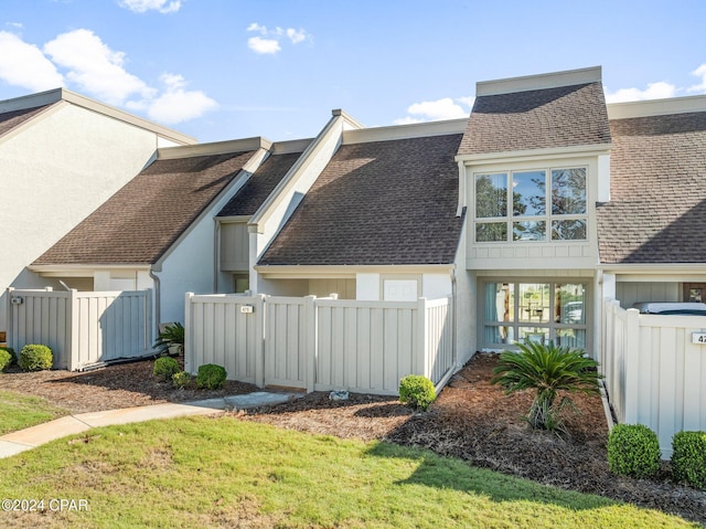 view of side of property with roof with shingles and fence