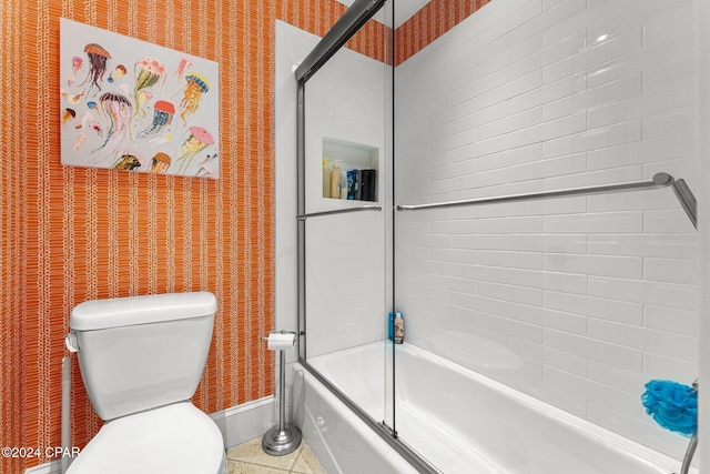 bathroom with toilet, wallpapered walls, enclosed tub / shower combo, and baseboards