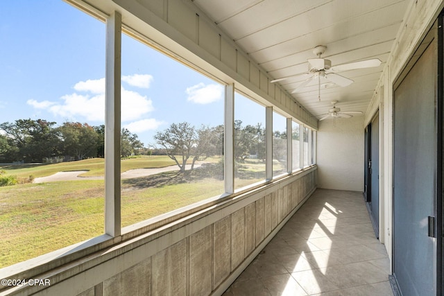 unfurnished sunroom with ceiling fan