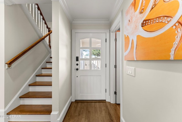 entryway featuring crown molding, stairs, baseboards, and wood finished floors