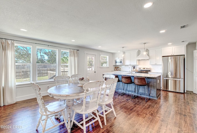 dining room with a textured ceiling, dark hardwood / wood-style floors, and sink