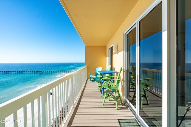 balcony featuring a water view and a beach view