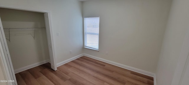 unfurnished bedroom with hardwood / wood-style flooring and a closet