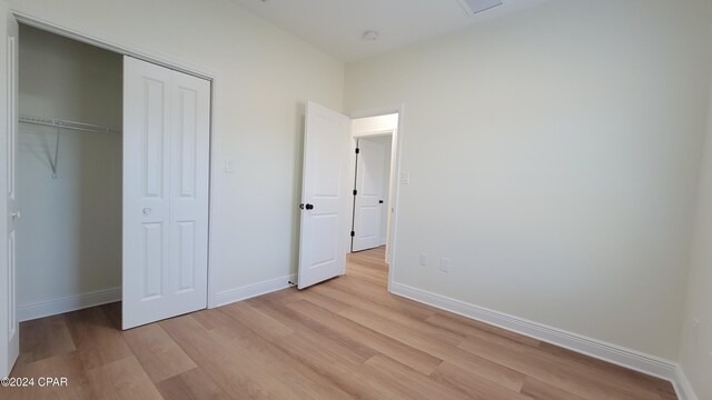 unfurnished bedroom with a closet and light hardwood / wood-style flooring