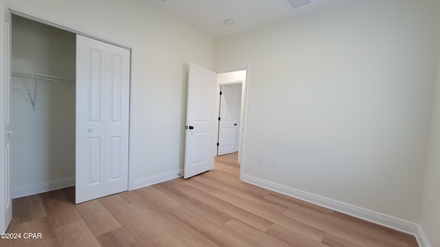 unfurnished bedroom with a closet and light hardwood / wood-style flooring