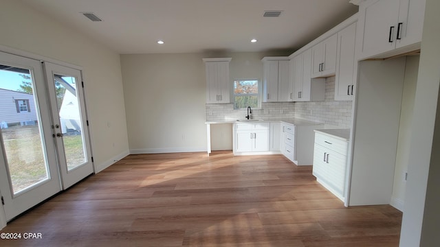 kitchen featuring tasteful backsplash, sink, and white cabinets