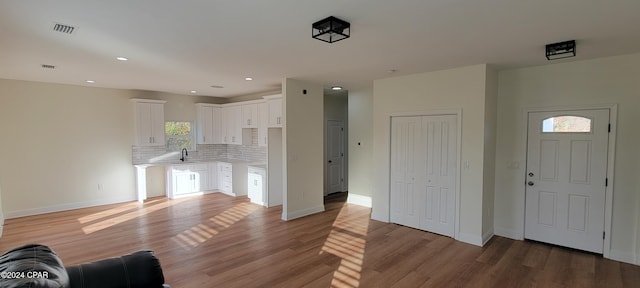 unfurnished living room with hardwood / wood-style flooring and sink