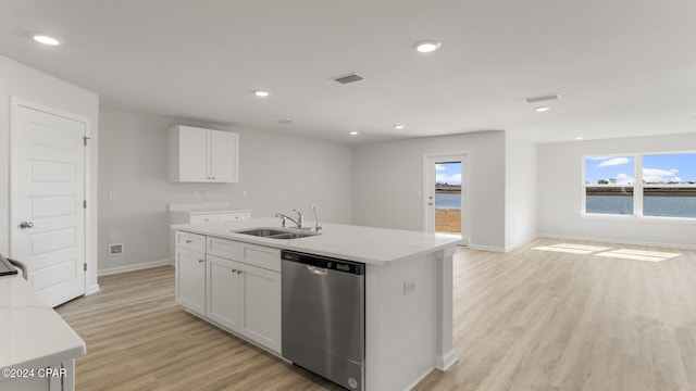 kitchen featuring white cabinets, sink, stainless steel dishwasher, light wood-type flooring, and light stone counters