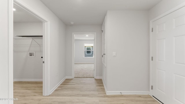 hallway with light hardwood / wood-style floors