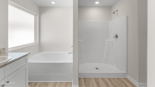 bathroom with vanity, wood-type flooring, and independent shower and bath