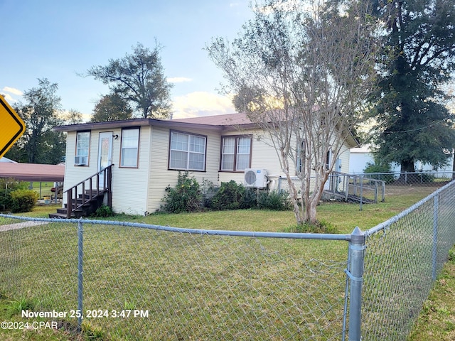 view of front of house featuring ac unit and a front yard