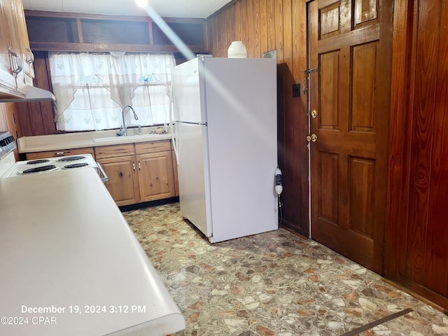 kitchen featuring sink, white fridge, and stove