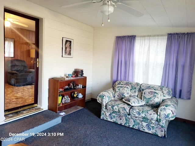 carpeted living room with wood walls