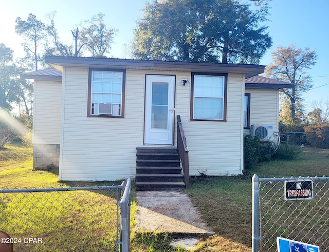 view of front of home with a front yard and ac unit